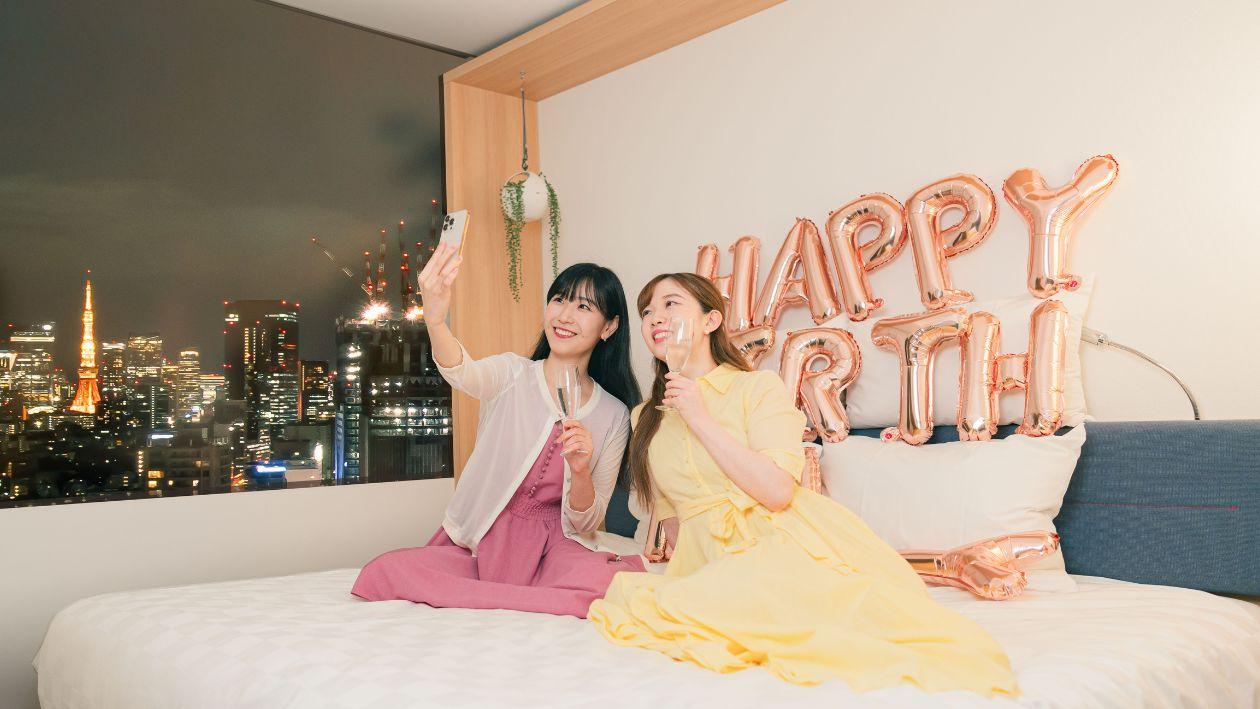 東京タワーが見える部屋で撮影をする女性2人