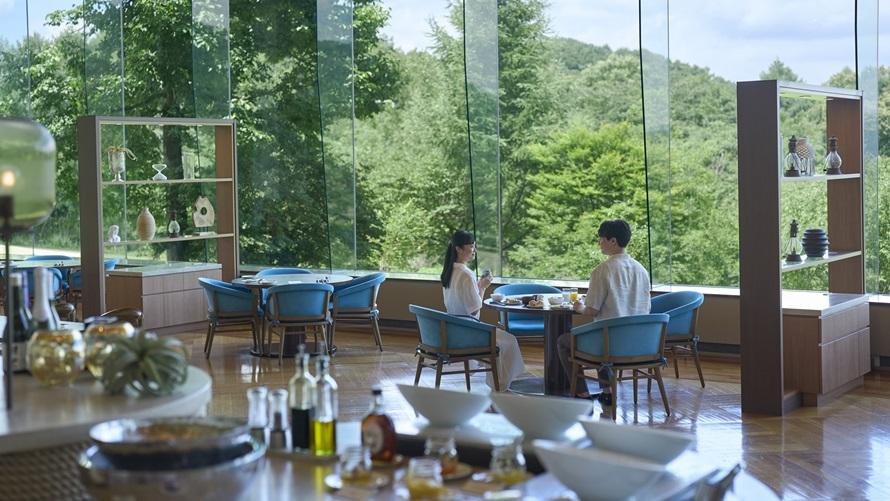 ダイニング ブルームのテーブルに並ぶ朝食ブッフェの料理の奥には浅間山の景色が広がる